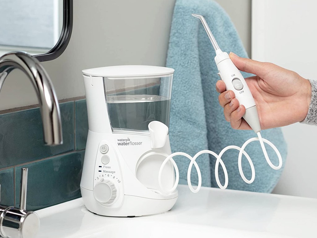 hand holding handle to white waterpik flosser