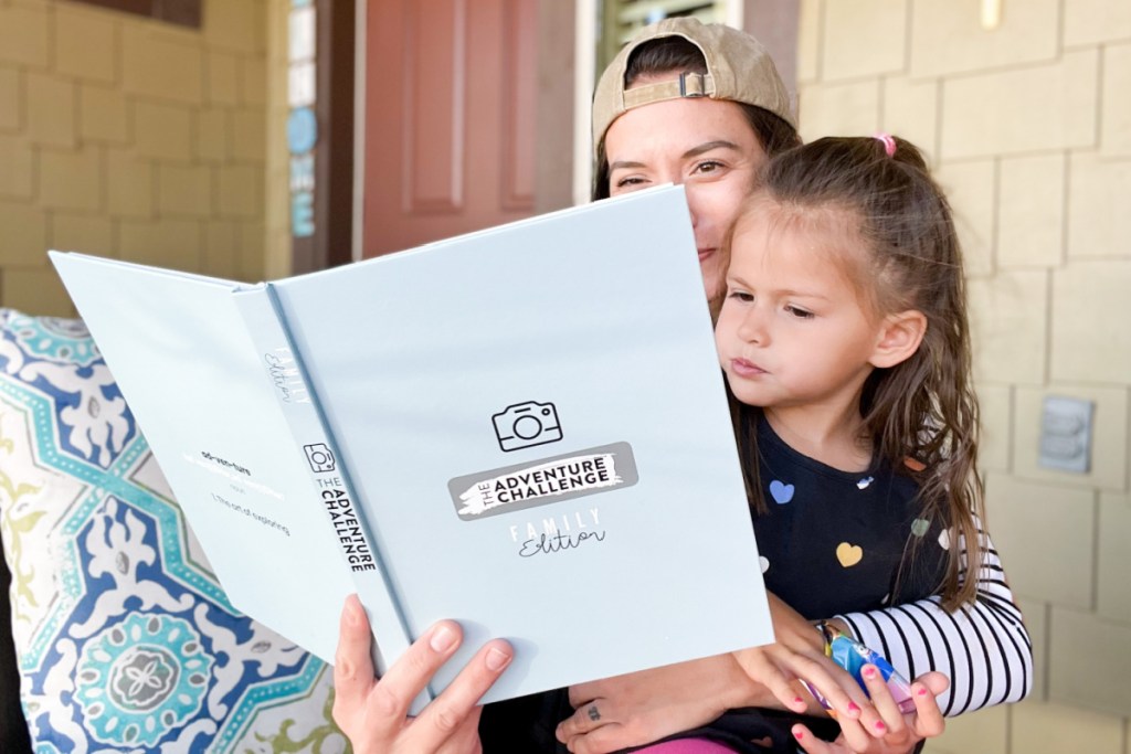 woman holding the adventure challenge family edition book with child on lap mothers day gifts 2023