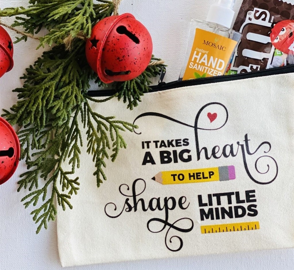it takes a big heart to shape little minds teacher gift pouch filled with goodies next to christmas greenery
