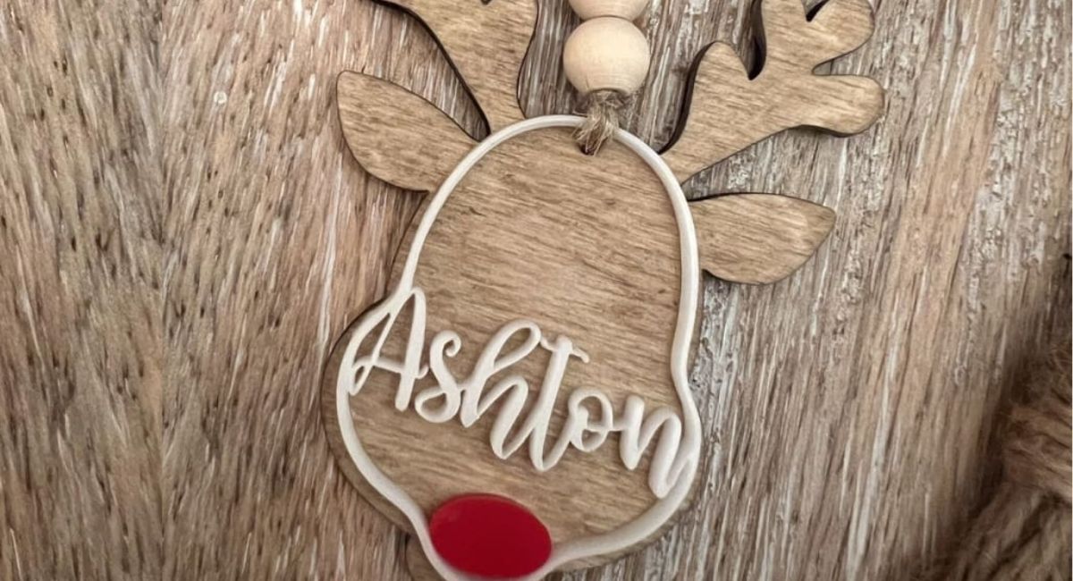 wooden reindeer shaped ornament with a red nose and the name ashton