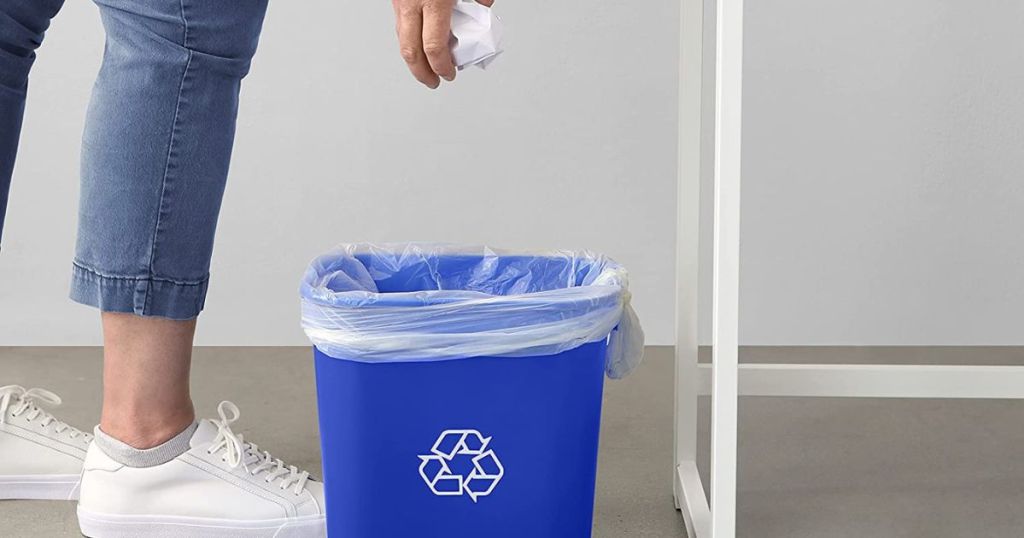 person throwing paper in wastebasket