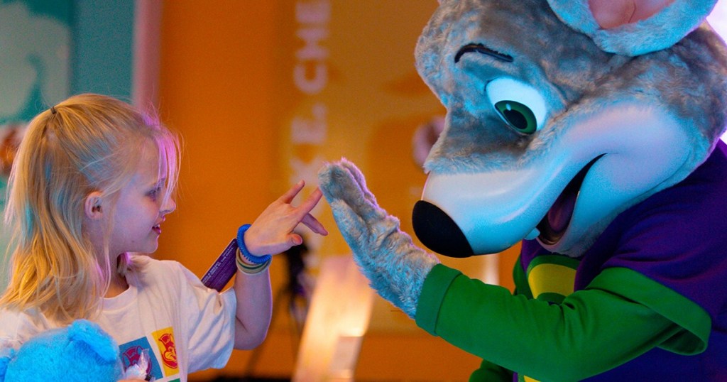 Chuck E Cheese mascot high-fiving a girl