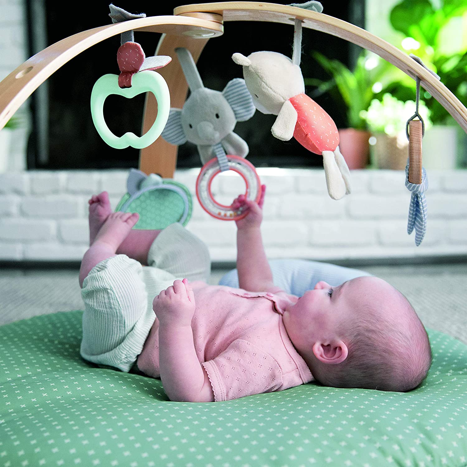 baby playing underneath cozy spot activity bars toys