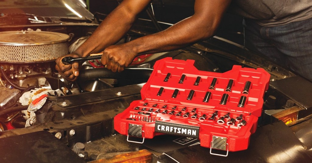 man working on car with red craftsman tool box