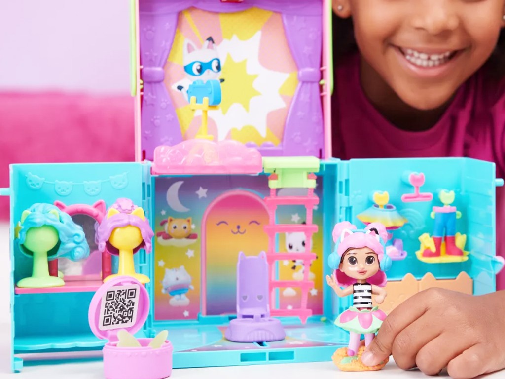 girl playing with Gabby's Dollhouse Rainbow Closet Portable Playset