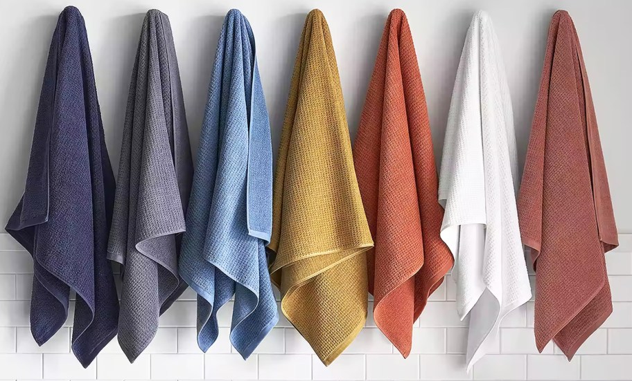 7 bath towels hung up on hooks