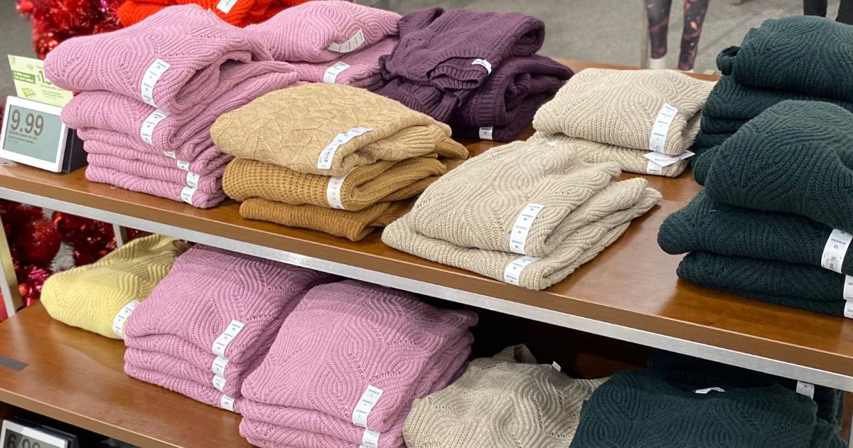 table full of folded women's sweaters at a store