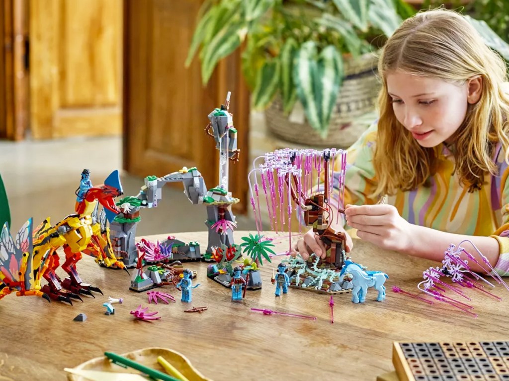 girl building lego avatar tree set
