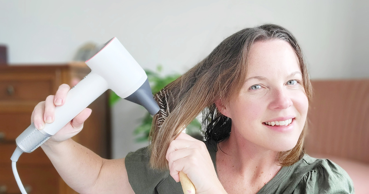 woman using a white hair dryer