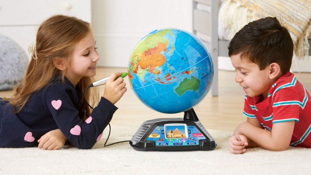 Two children sitting on the floor playing with the LeapFrog My Adventures Globe