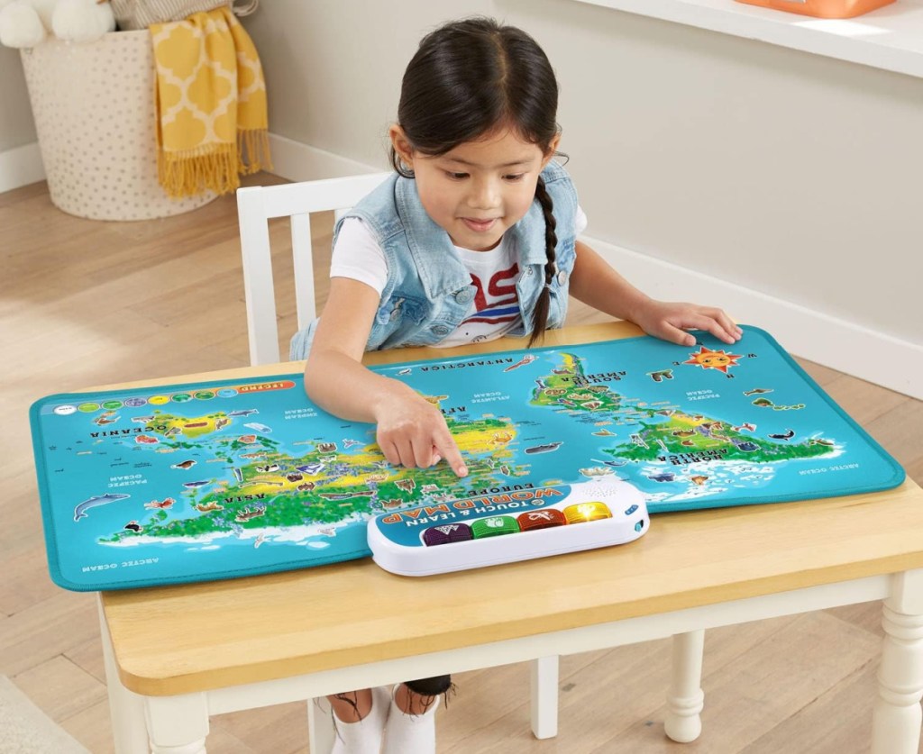 Girl playing with the interactive LeapFrog World Map