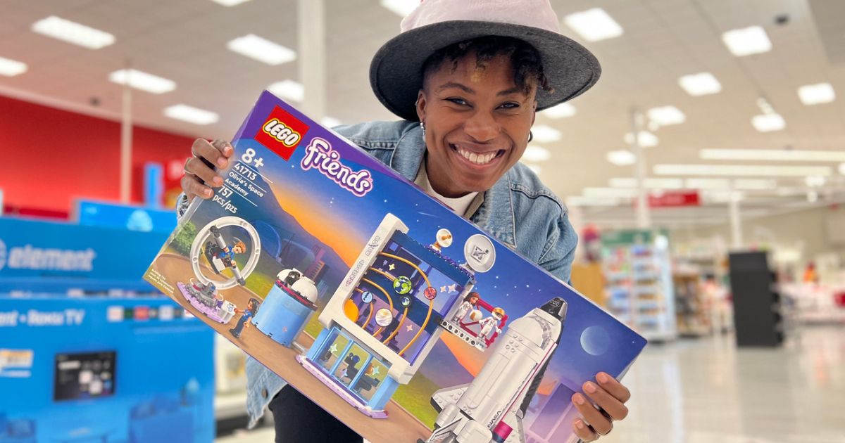 Woman in a hat hold the LEGO space academy box in the store