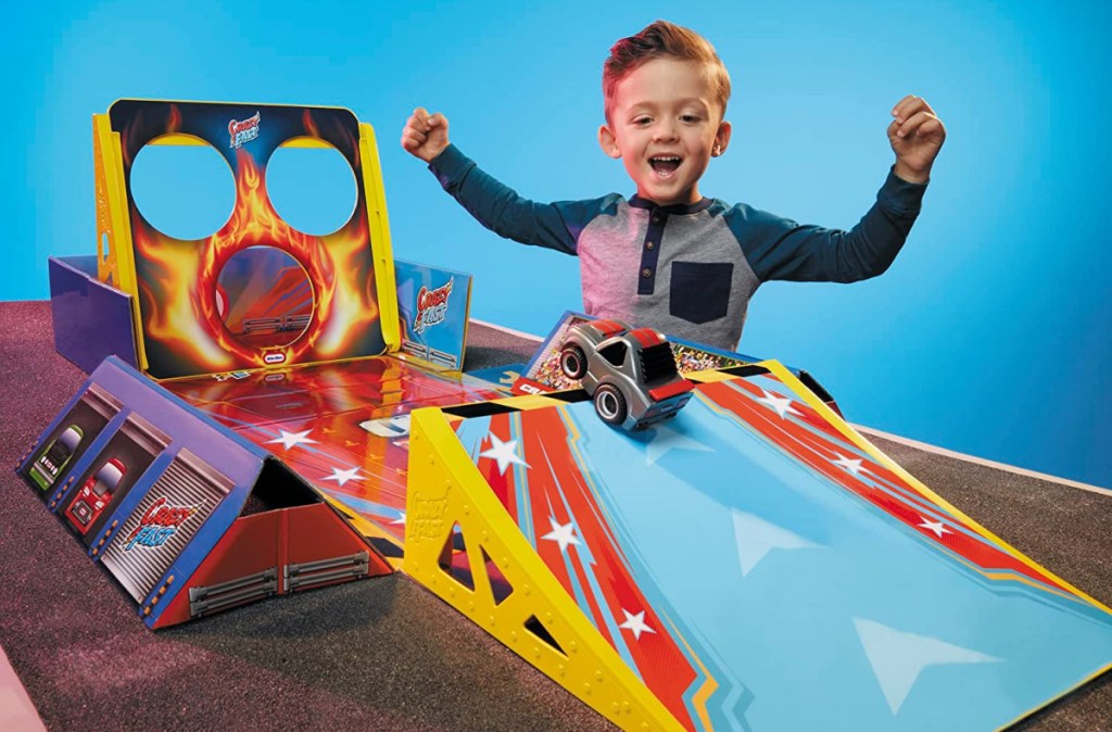 boy cheering as he plays with a little tikes my first cars playset