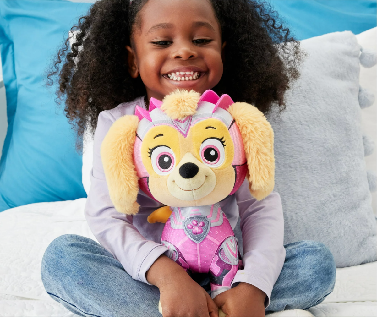 Girl holding a Paw Patrol Plushie Toy of Skye which is one of the top Walmart Christmas toys for 2023