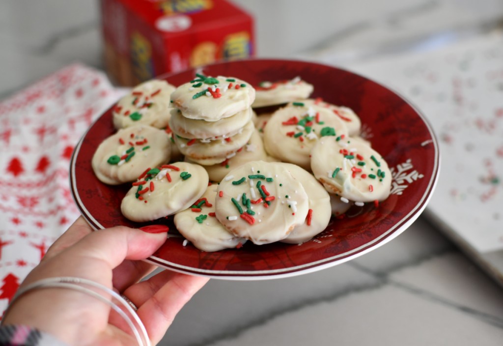 Hand holding a plate of homemade Thin Mint cookies made of white chocolate