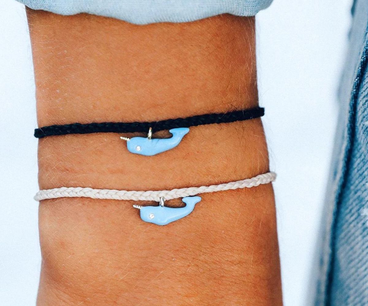 a wrist with two Pura Vida save the narwhalNarwhal charm