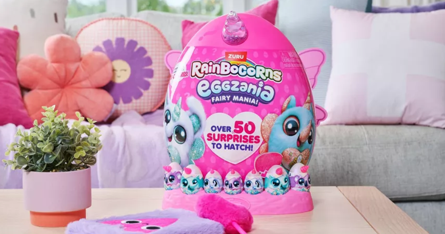 a pink egg Rainbocorns Eggzania Fairy Mania toy on a coffee table in a living room