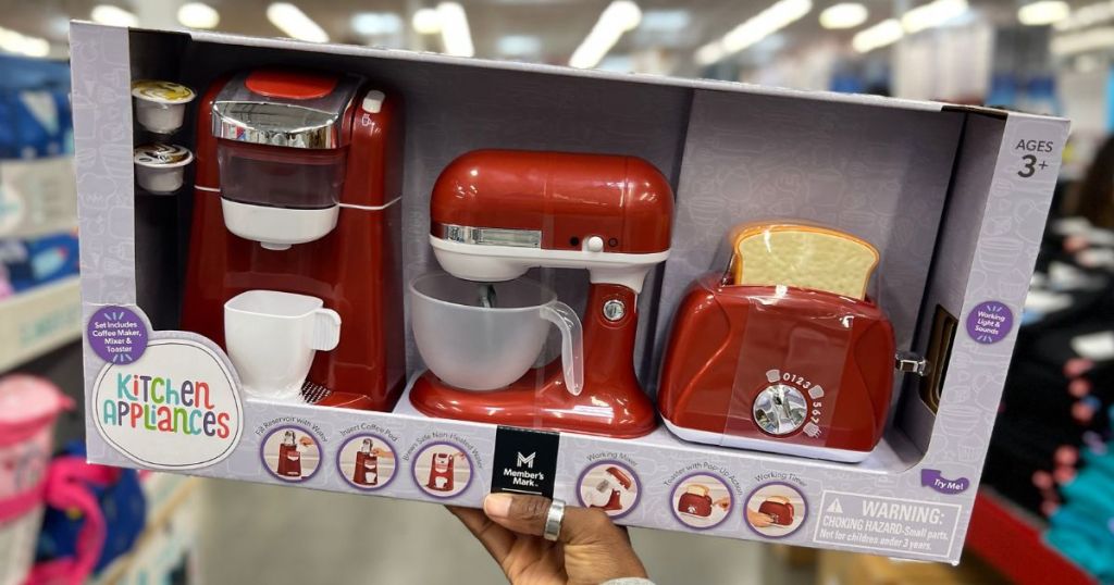 Hand holding up a Member's mark 3-piece toy appliance set