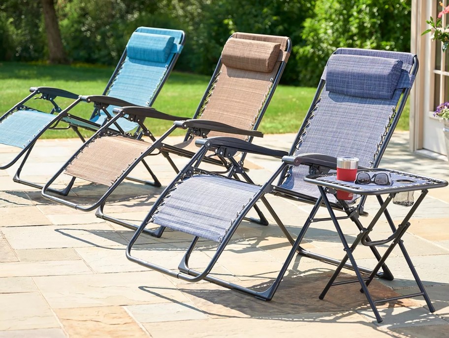 Three zero gravity chairs in a row on a patio