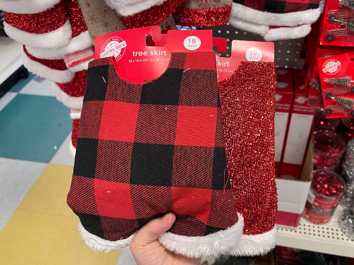 A hand holding up two Christmas tree skirts