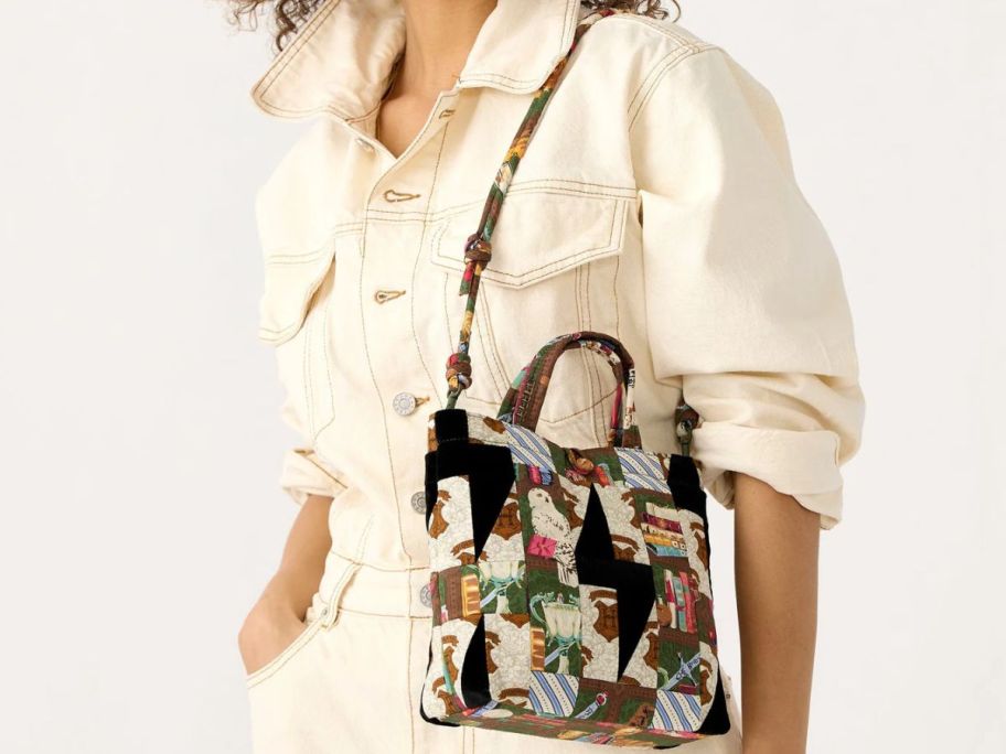 Woman carrying a Vera Bradley Harry Potter Hogwarts Library Patchwork Mini Original Tote over her shoulder