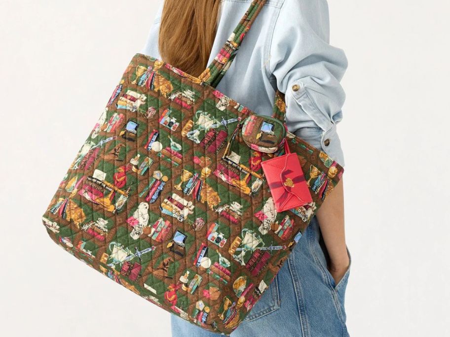 Woman with a Vera Bradley Harry Potter Hogwarts Library Original Zip Tote with two bag charms hanging over her shoulder