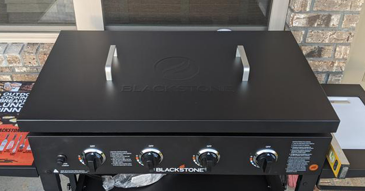 blackstone griddle hard cover resting on the grill