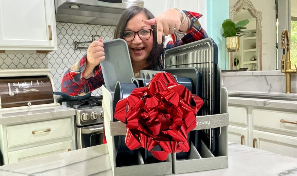 woman pointing down at caraway bakeware set with big red bow