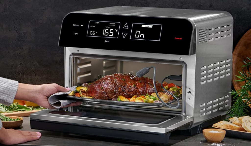 hand putting food in oven