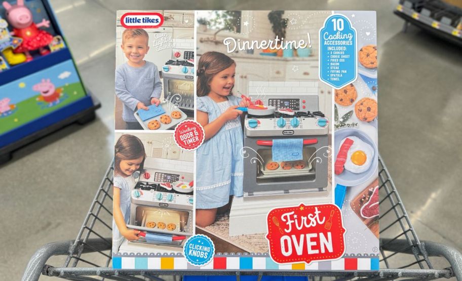 a box containing little tikes first oven sitting in a shopping cart in a walmart store