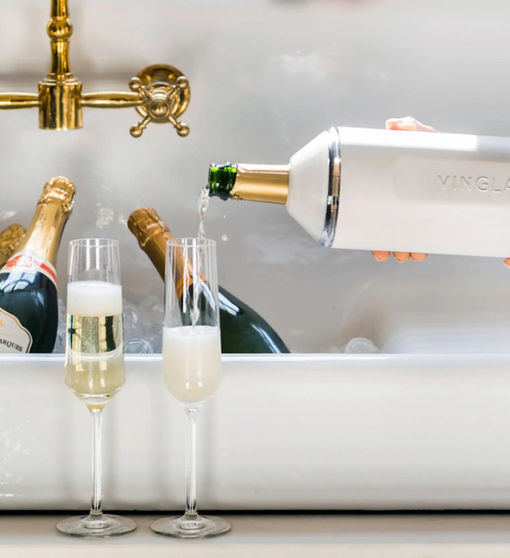 hand pouring champagne into glasses on kitchen counter