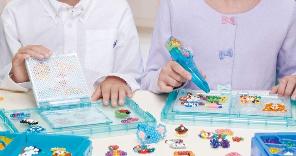 kids playing with aquabead sets