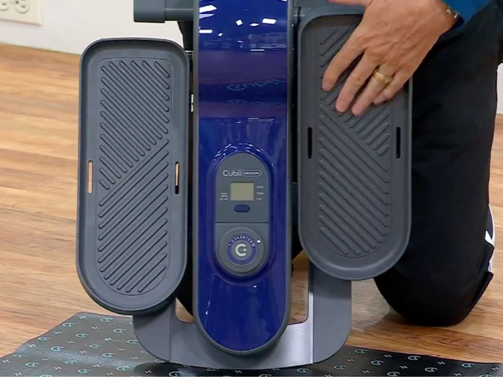 Man holding up a cubii groove seated elliptical