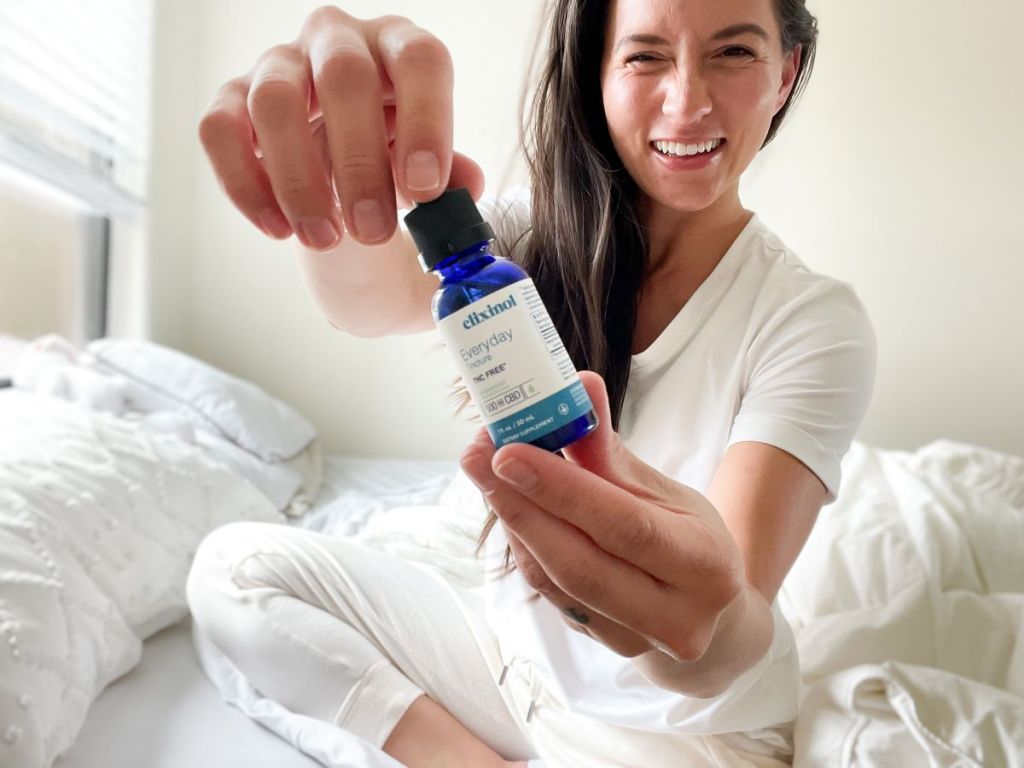 woman holding an Elixinol Tincture