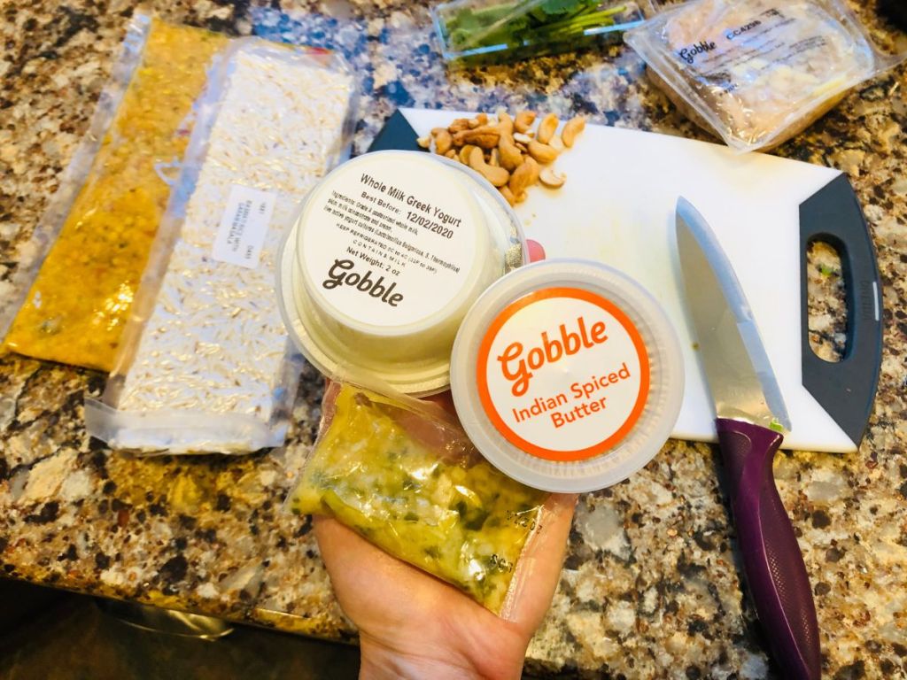 A hand holding a number of Gobble Box ingredients