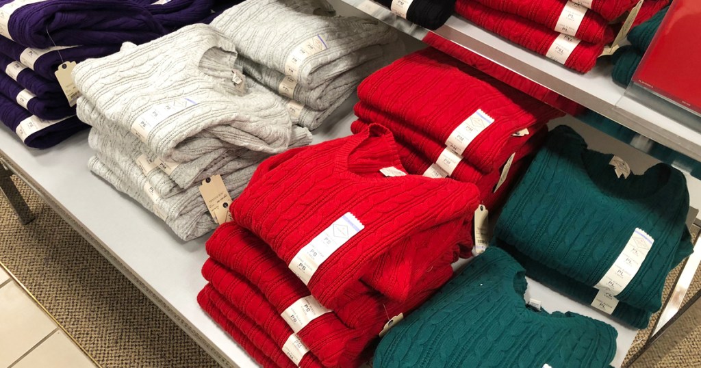 display of folded women's cable knit sweaters in store