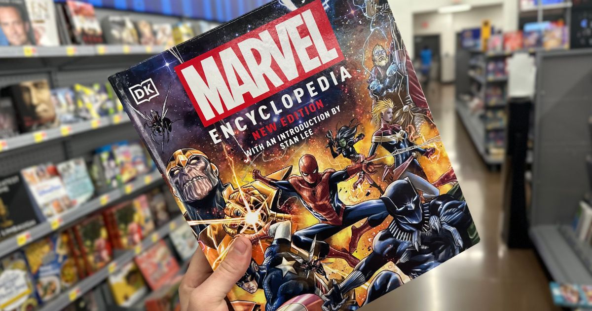 A hand holding a copy of the Marvel comics encyclopedia