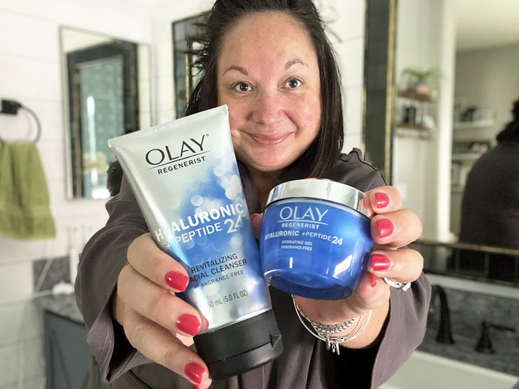 woman holding up olay moisturizer and cleanser