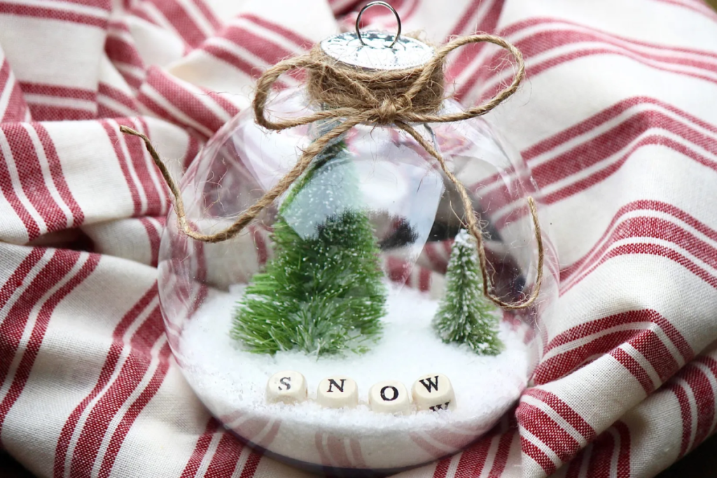 A DIY Snow globe ornament depicting a winter scene from She's Crafty and She Knows It