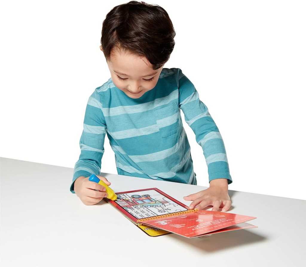 Boy playing on a water reveal activity pad he got in his christmas stocking