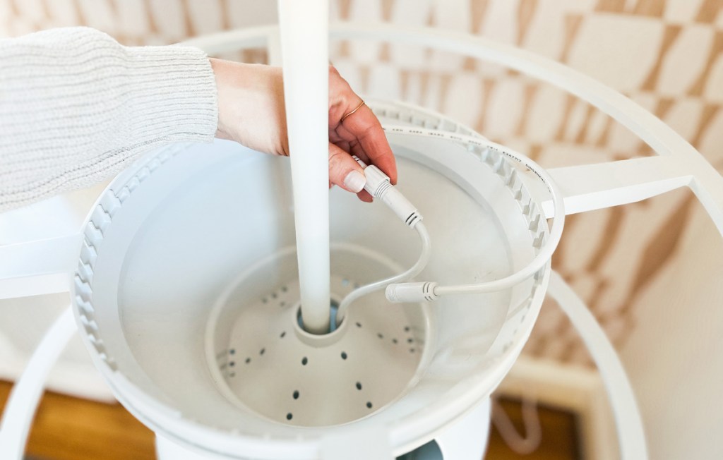 hand holding wire to grow lights on hydroponic garden