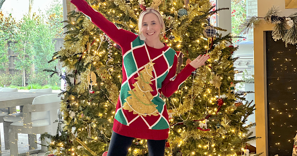 Collin wearing Christmas sweaters in front of tree 