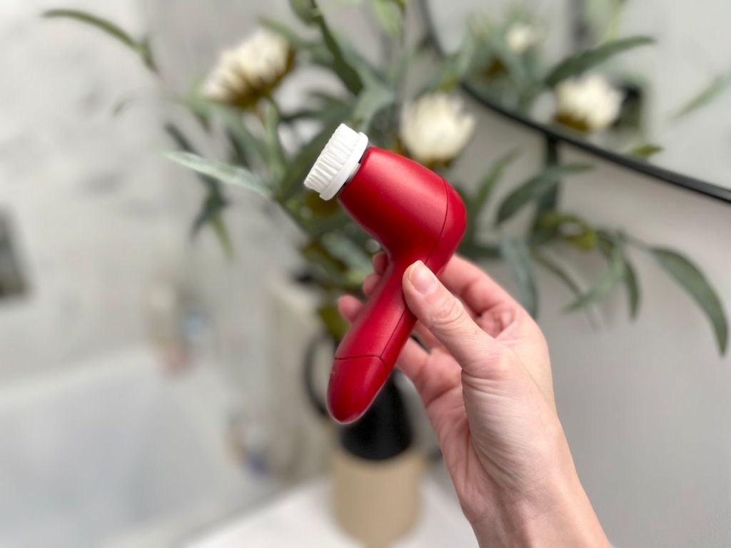 hand holding an olay cleansing brush