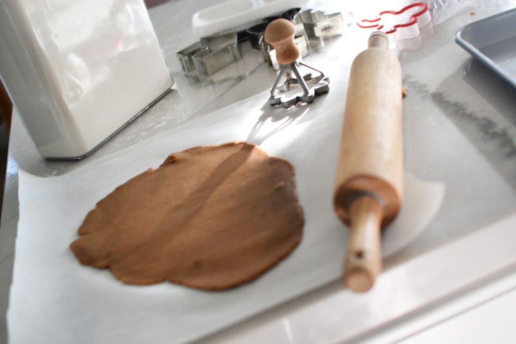 rolling out gingerbread dough onto parchment paper
