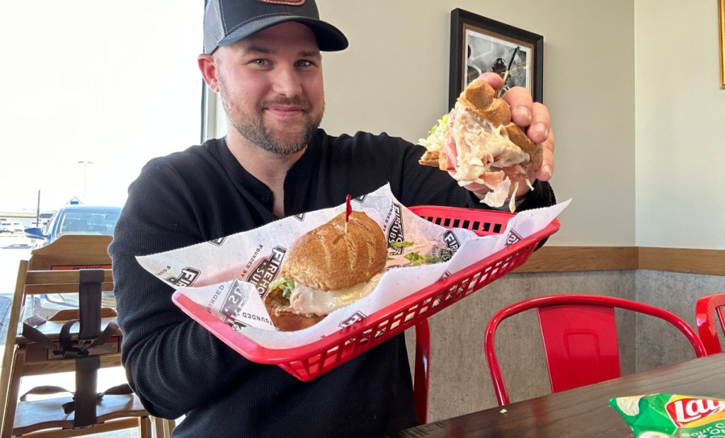 man holding a red basket with a firehouse sub in it - fast food hacks