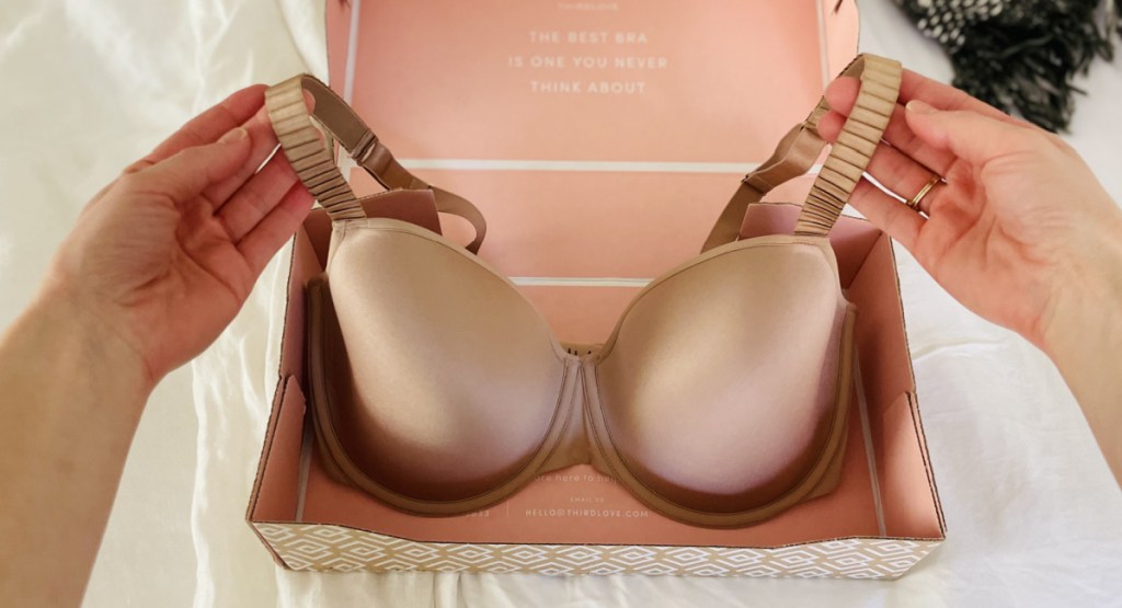 hands holding bra in box