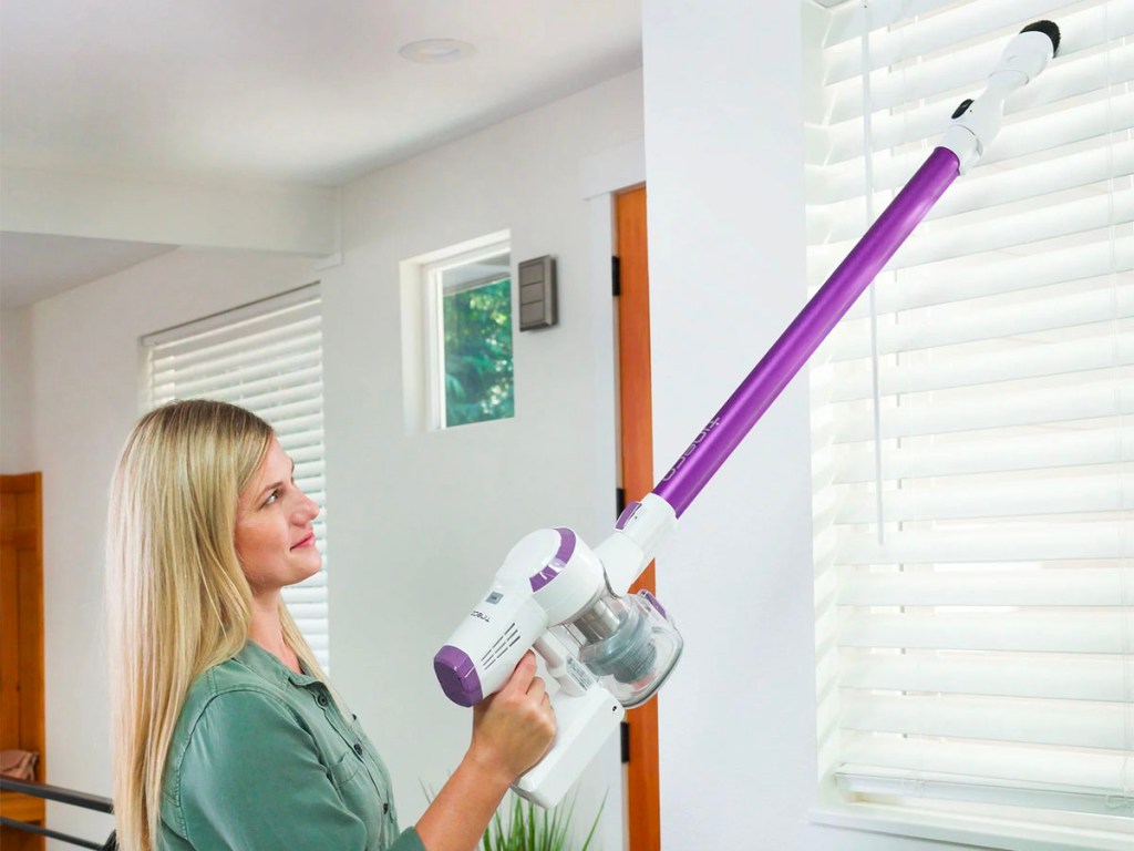 woman using purple and white tineco vacuum