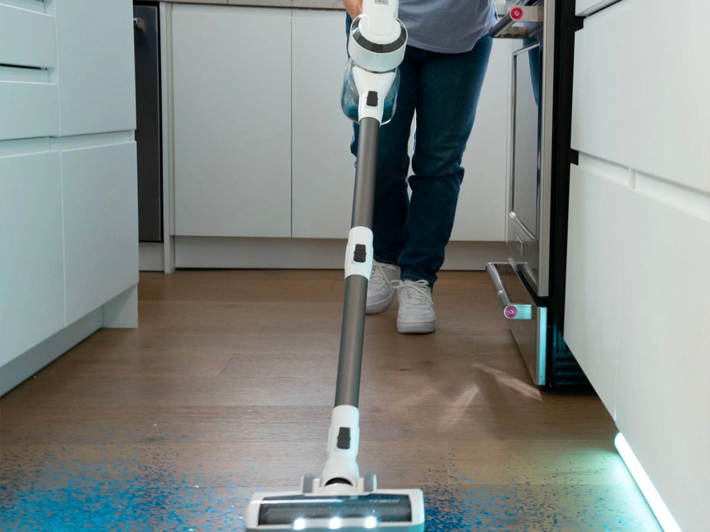 woman using gray and white tineco vacuum