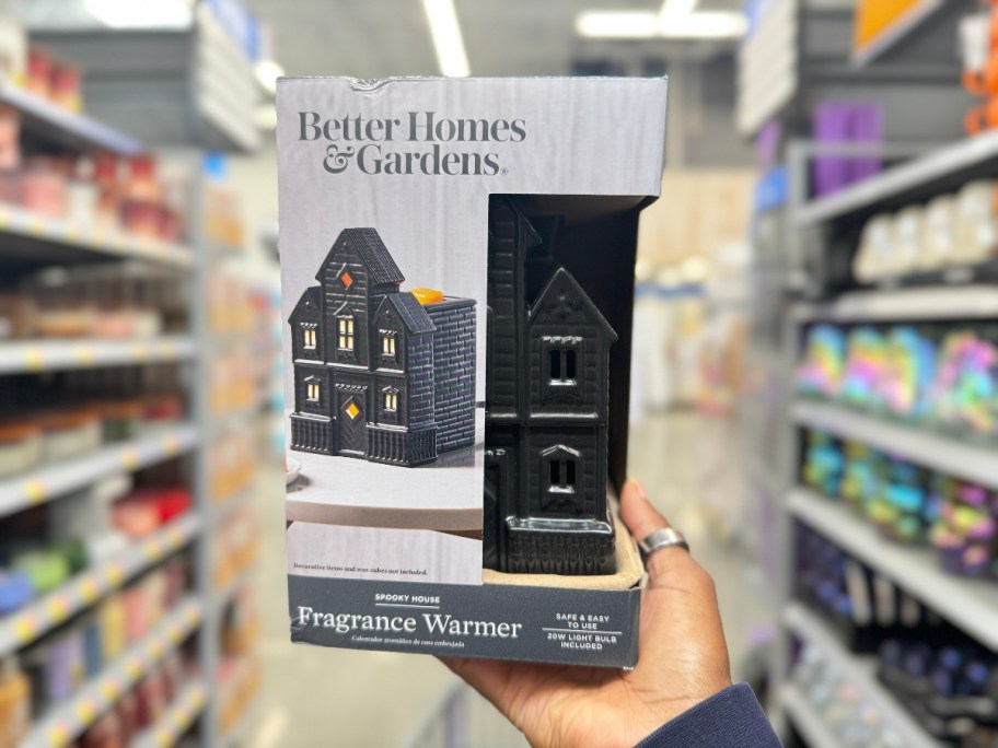 hand holding a black haunted spooky house shaped wax warmer in a box at Walmart