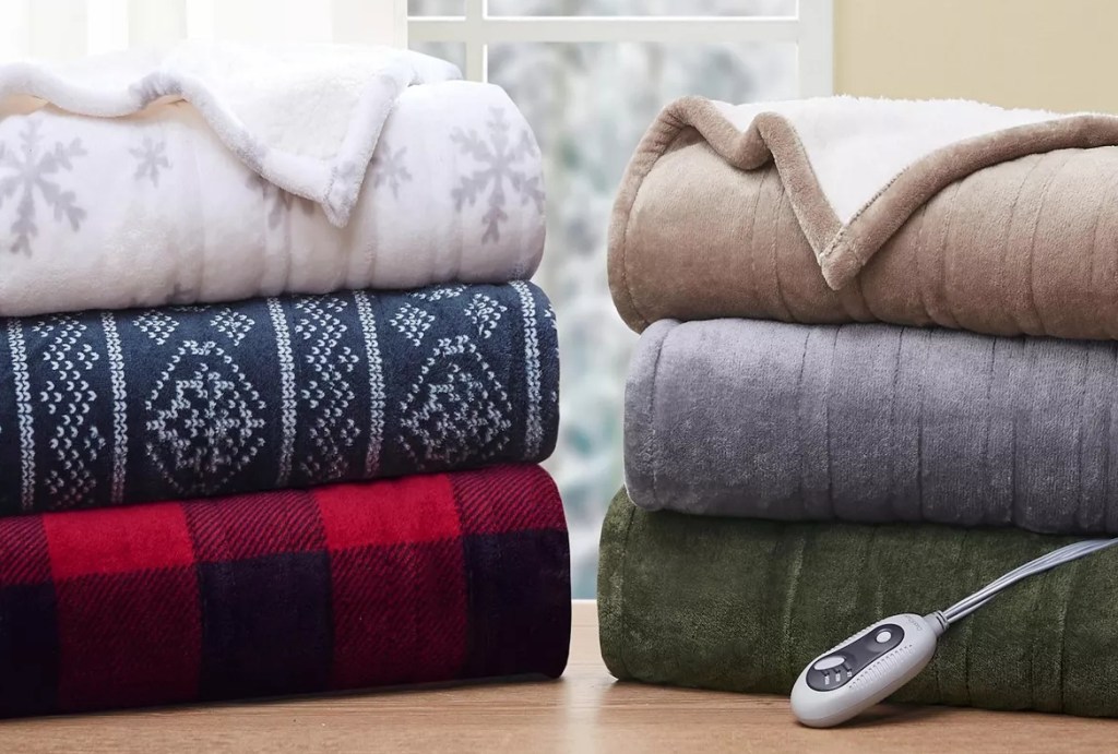 Two stacks of folded Cuddl Duds plush electric throws